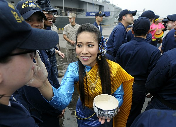 Thai dancers in traditional dress perform a cleansing ritual for US Navy sailors during Songkran festival.