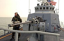 One of two crew-served Mk 38 25 mm autocannons carried aboard Chinook in 2003 030321-N-0000G-006 - Sailor scans the horizon for contacts and potential aggressors from aboard the Cyclone-class patrol boat, USS Chinook (PC-9).jpg