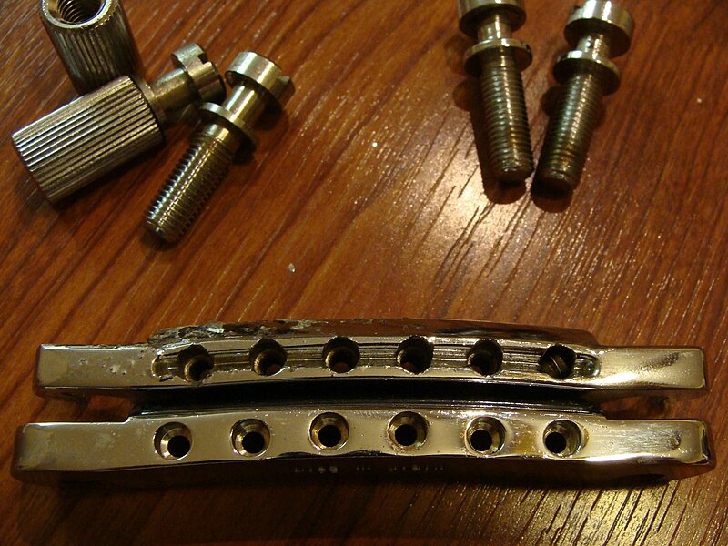 File:1973 Gibson Les Paul Deluxe (SN 620310) Stopbar tailpieces (tail) - original chrome-plated aluminum 'featherweight' tailpiece (1.05 oz) & 1980s plated brass replacement 'Made in Japan' as sold by Leo Quan or Badass (4.00 oz) (2010-02-06 by TT Zop).jpg