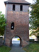 Tor- und Glockenturm mit romanischem und vermauertem gotischen Fenster und neuerem Glockengeschoss