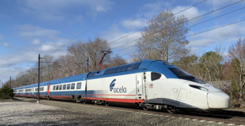 A passenger trainset with a white window stripe and blue above and below. The end car has a gray nose and red sill stripe.