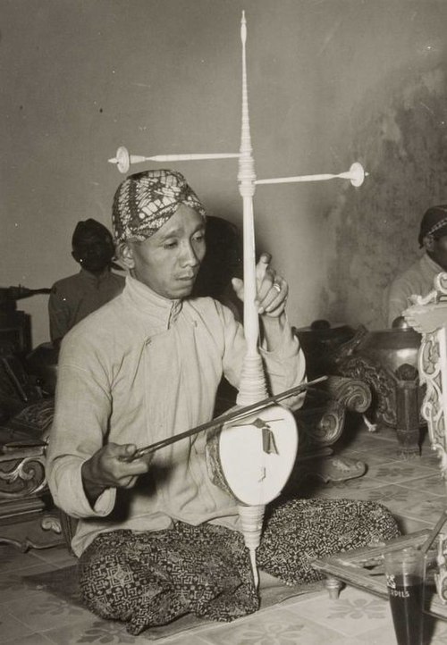 An Indonesian music performer playing with his Rebab.