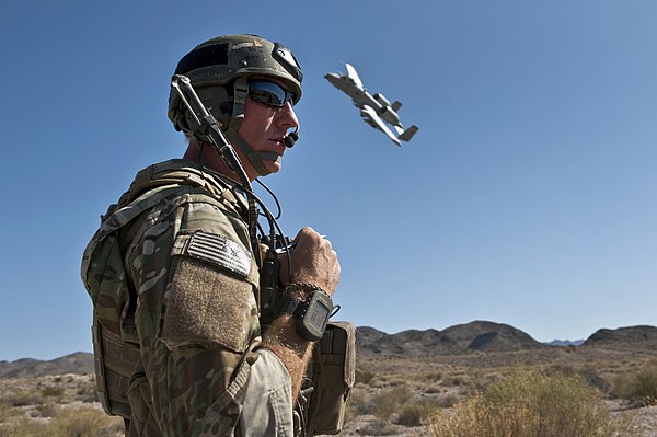 A United States Air Force joint terminal attack controller using a radio to coordinate close air support with an A-10 Thunderbolt II