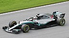 a grey open wheeled racing car is driven around a track