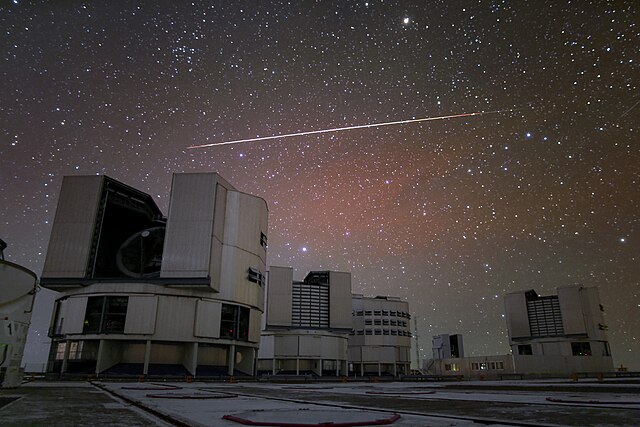 A bright artificial satellite flare is visible above the Very Large Telescope. Satellite constellations could have an impact on ground-based astronomy