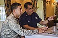 A U.S. Coast Guard auxiliarist (right) provides English-to-Spanish translation for a member of the Dominican Republic coast guard during Tradewinds 2013, a U.S.-led multinational military exercise in the Caribbean basin.