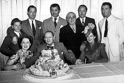 Lionel Barrymore's 61st birthday in 1939, standing: Mickey Rooney, Robert Montgomery, Clark Gable, Louis B. Mayer, William Powell, Robert Taylor, seated: Norma Shearer, Lionel Barrymore, and Rosalind Russell