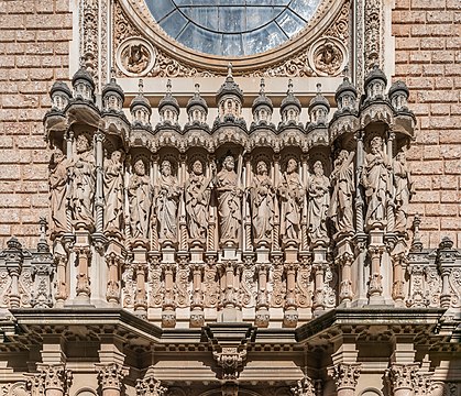 Cristo e os apóstolos na fachada da abadia da Basílica de Montserrat, em Monistrol de Montserrat, Catalunha, Espanha. A Basílica de Montserrat começou a ser construída no século XVI e foi totalmente reconstruída no século XIX (1811) após a sua destruição na Guerra da Independência. Em 1881 o Papa Leão XIII concedeu-lhe o estatuto de basílica menor. A fachada foi realizada em 1901, obra de Francisco de Paula del Villar y Carmona em estilo neoplateresco, uma mistura de estilos arquitetônicos que surgiram na Espanha no final do século XIX e início do século XX, com relevos escultóricos de Venancio e Agapito Vallmitjana. Após a Guerra Civil, foi construída uma nova fachada, obra de Francisco Folguera e decorada com relevos escultóricos de Joan Rebull. (definição 3 976 × 3 420)