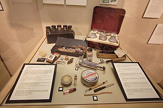 A mortician's restorative tools, amongst which includes eye caps and packing material for cavities, as well as smaller bottles of preserving fluid. Mortician's resorative tools.JPG