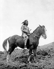 Photo noir et blanc d'un Nord-Amérindien torse nu sur son cheval.