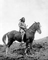 Воин из племени не-персе в набедренной повязке и мокасинах верхом на коне, около 1910.