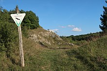 Das Bild zeigt einen aufgelassenen Kalksteinbruch auf der Nordsteite des Pfannentals, vor dem ein Schild mit der Aufschrift "Landschaftsschutzgebiet" steht.