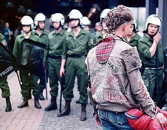 A punk faces a line of riot police at a 1984 protest in Germany