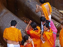 Praying at the feet of a statue of Bahubali Shravanbelgola Gomateshvara feet prayer1.jpg