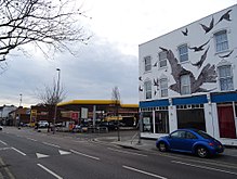 Petrol station at the site of 517 High Road, Leytonstone, where Hitchcock was born; commemorative mural at nos. 527-533 (right) Site of 517 High Road Leytonstone London E11 3EE (Birthplace of Alfred Hitchcock).jpg