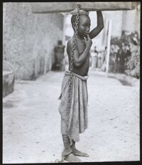A slave boy in Zanzibar punished by his master for a slight offence. The log weighed 32 pounds, and the boy could only move by carrying it on his head, circa 1890 Slavery in Zanzibar RMG E9093.tiff