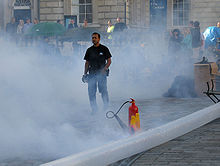 A special effects engineer positions the inflatable plastic tube feeding the smoke. Smoke Machine engineer.jpg
