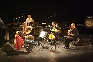 Steve Reich Ensemble playing Different Trains (from left to right) Liz Lim-Dutton, violin, Todd Reynolds, violin, Jeanne LeBlanc, cello, Scott Rawls, viola, Russ Hartenberger at the back Steve Reich Ensemble playing Different Trains.jpg