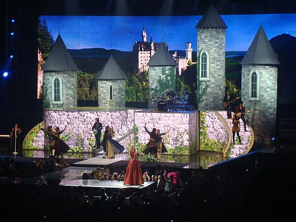 Swift (in red) performing "Love Story"; the two-leveled main stage included a LED back wall onto which images and videos were projected and three wind