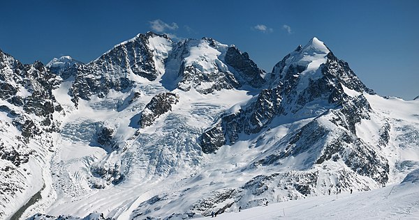 Piz Bernina (centre-left) with the Biancograt to the left, Piz Scerscen (centre-right) and Piz Roseg (right), seen from Piz Corvatsch