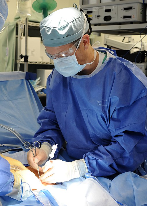 US Navy 110511-N-CW427-002 Cmdr. Gordon Wisbach prepares to insert an endoscope through a patient's belly button before performing a natural orific