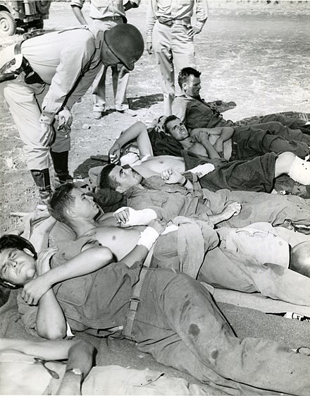 Patton talks to wounded soldiers preparing for evacuation