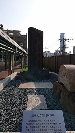 ノースゲートビルディングと立体駐車場をつなぐ通路に移設された清水太右衛門殉職碑