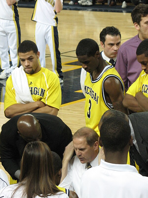 Beilein in the huddle with Manny Harris looking over his shoulder.