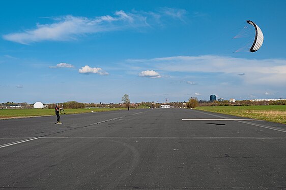 A kiteskating man looking up to his kite