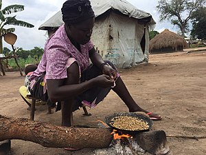 Eine Mutter röstet Kaffeebohnen im Rhino-Flüchtlingslager im Nordwesten Ugandas