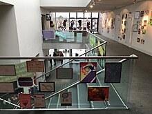 Upper foyer looking over the stairway towards the entrance, with a Barnardo's children's art exhibition on display. Beacon Arts Centre foyer.jpg