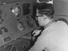 Bill Wallace operates the range and bearing controls of a GL Mk. III radar while tracking a weather balloon for the Met Office during the 1950s. Bill Wallace operating GL Mk III radar at Met Office.jpg