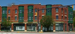 A block of red and green painted three-story apartment buildings