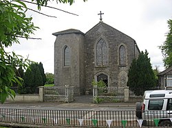 The parish RC church The inscribed stone high up in the gable reads "THIS TEMPLE was erected to the honour and glory of GOD By the Revd George Canavan P.P. in the year of our Lord 1836"