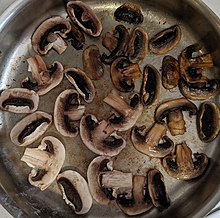 Common white mushrooms cooking, from raw (in the lower left) to cooked (in the upper right).