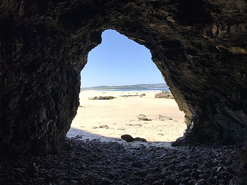 A cornish beach viewed from within a cave