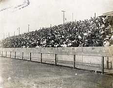 Большая толпа сидит на стадионе и смотрит спортивные соревнования.