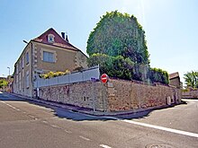 Photographie en couleurs d'une maison particulière précédée d'un jardin en terrasse.