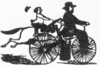 A drawing of an early velocipede with a steam engine passing a rider on horseback