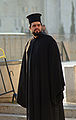 Um clérigo ortodoxo grego usando uma batina externa (exorason) e camelauco