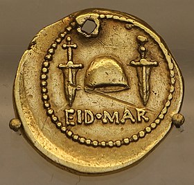Nummus aureus: EID MAR (h.e. Idibus Martiis), pilleus, duae sicae. Marcus Iunius Brutus hunc ob Caesaris interfectionem cudere iussit.