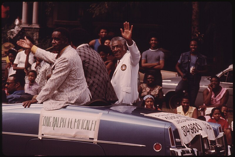 File:ILLINOIS CONGRESSMAN RALPH H. METCALFE (WHITE COAT) GREETING CONSTITUENTS DURING THE BUD BILLIKEN DAY PARADE, ONE OF... - NARA - 556273.jpg