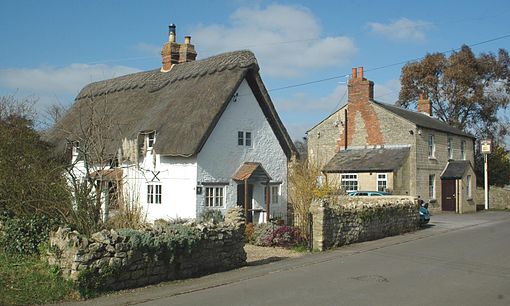 4 Bridge Road is a 17th-century thatched cottage whose front was rebuilt in the 18th century.[13] The stone building in the background is the Royal Oak public house, which is no longer trading.