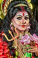 Indian female artist in face makeup to resemble goddess