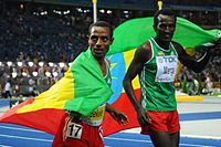 Kenenisa Bekele und der viertplatzierte Imane Merga (rechts) auf einer Ehrenrunde