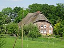 Hall building and brick farm building on the left as well as half-timbered retirement part building on the right