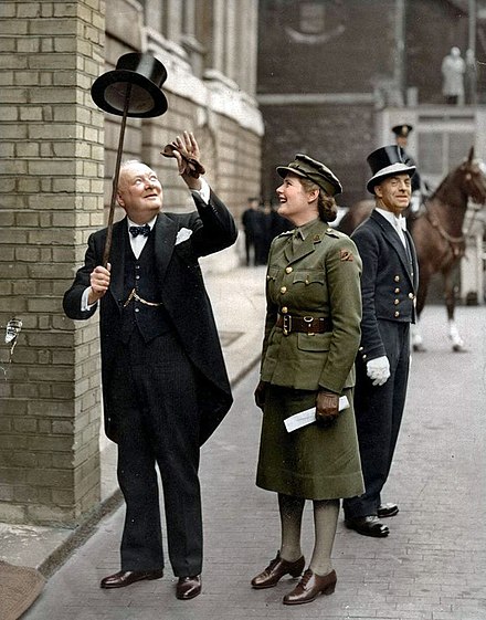 Winston Churchill in morning dress, lifting his top hat with his walking stick (1943).