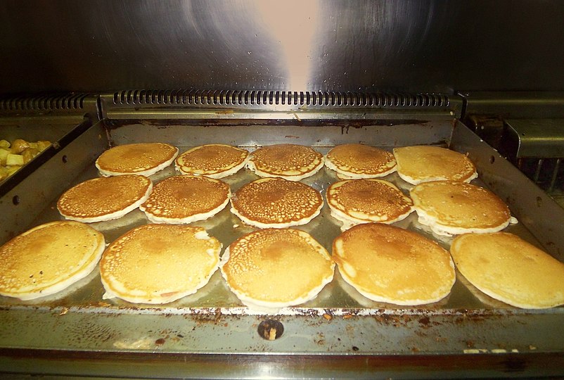 Pancakes cooking on a commercial griddle