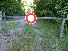 Panneau sur une barrière barrant l'accès à un chemin forestier