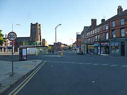 Streetscape showing the Penny Lane roundabout (centre left) and shops in 2018